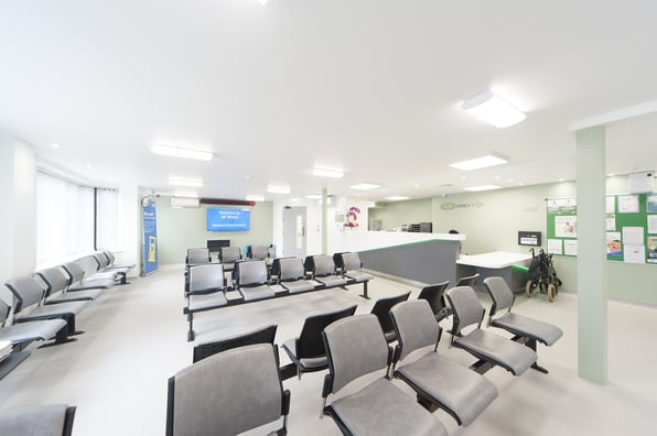 An empty restructured waiting room in a modern medical centre with lot of chairs and energy saving LED lighting