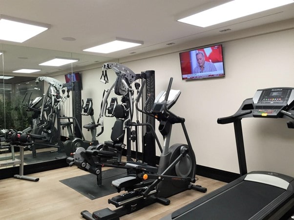 a basement converted into a gym with treadmills, cross trainers, weight machines and a TV on the wall to show the key signs that it's time for a basement conversion